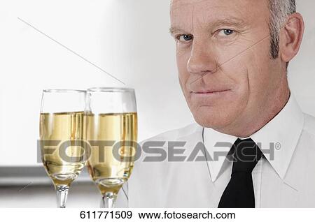 Waiter holding a tray of champagne flutes View Large Photo Image Stock Photo - Waiter holding a tray of champagne flutes. Fotosearch