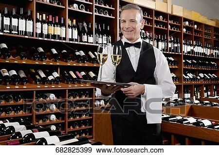 Waiter holding a tray of champagne flutes View Large Photo Image Stock Photo - Waiter holding a tray of champagne flutes. Fotosearch