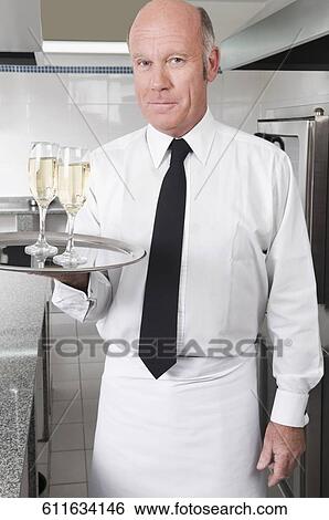 Waiter holding a tray of champagne flutes View Large Photo Image Stock Photograph - Waiter holding a tray of champagne flutes. Fotosearch