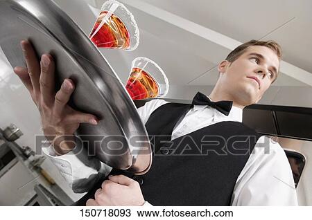 Waiter holding a tray of martini View Large Photo Image Stock Image - Waiter holding a tray of martini. Fotosearch
