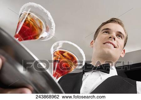 Waiter holding a tray of martini View Large Photo Image Stock Image - Waiter holding a tray of martini. Fotosearch