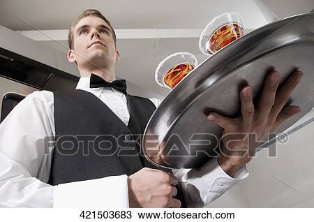 Waiter holding a tray of martini View Large Photo Image Stock Image - Waiter holding a tray of martini. Fotosearch