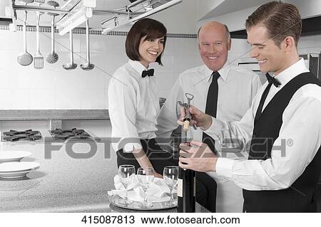 Stock Image - Waiter opening a wine bottle. Fotosearch