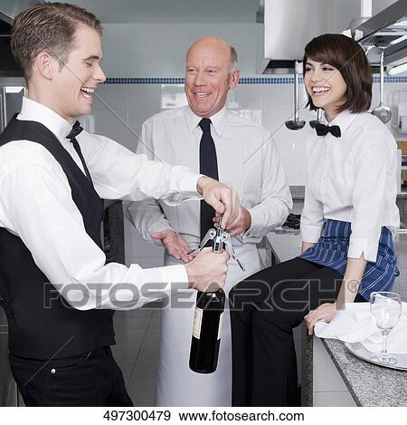 Waiter opening a wine bottle View Large Photo Image Stock Photo - Waiter opening a wine bottle. Fotosearch