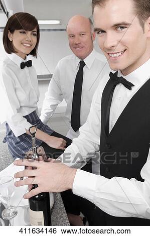 Stock Photograph - Waiter opening a wine bottle. Fotosearch