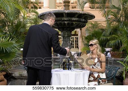 Waiter serving drink to woman in a hotel garden, Biltmore Hotel, Coral Gables, Florida, USA View Large Photo Image Stock Photography - Waiter serving drink to woman in a hotel garden, Biltmore Hotel, Coral Gables, Florida, USA. Fotosearch