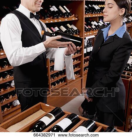 Waiter showing a wine bottle to a businesswoman View Large Photo Image Stock Image - Waiter showing a wine bottle to a businesswoman. Fotosearch