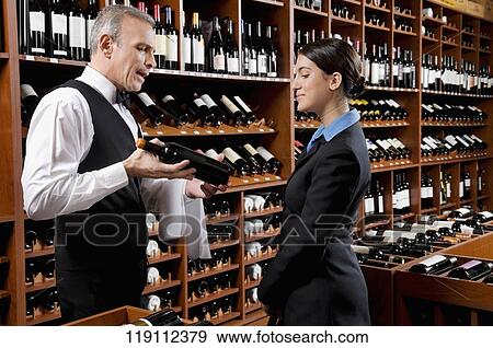 Waiter showing a wine bottle to a businesswoman View Large Photo Image Stock Photo - Waiter showing a wine bottle to a businesswoman. Fotosearch