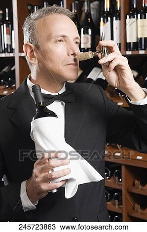 Waiter smelling cork of a wine bottle View Large Photo Image Stock Image - Waiter smelling cork of a wine bottle. Fotosearch