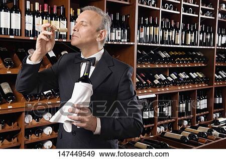 Waiter smelling cork of a wine bottle View Large Photo Image Stock Photo - Waiter smelling cork of a wine bottle. Fotosearch