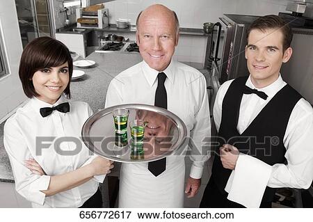 Waiters standing in the kitchen and smiling View Large Photo Image Stock Photo - Waiters standing in the kitchen and smiling. Fotosearch