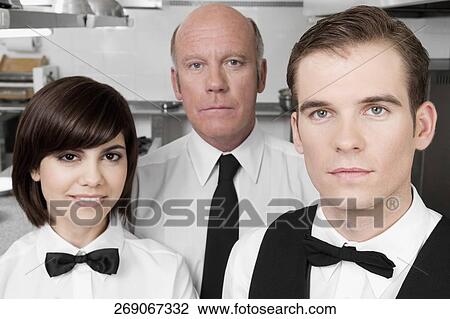 Stock Image - Waiters standing in the kitchen. Fotosearch