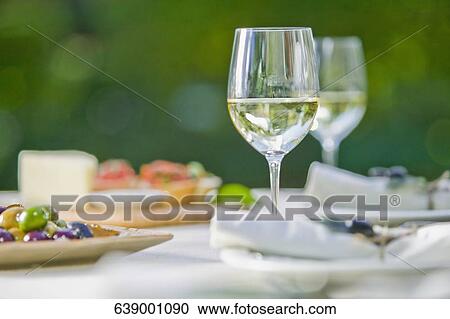 Wine glass with olives on a table View Large Photo Image Stock Image - Wine glass with olives on a table. Fotosearch