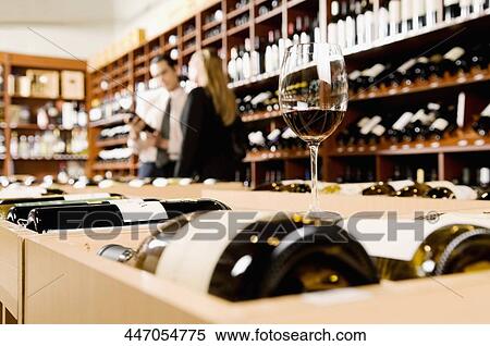 Stock Photography - Wine glass with wine bottles in a bar. Fotosearch