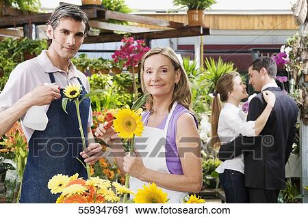 Woman and a man working in a greenhouse View Large Photo Image Stock Image - Woman and a man working in a greenhouse. Fotosearch