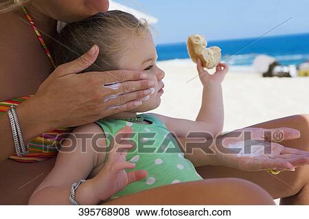 Woman applying suntan lotion to her daughter, Cabo San Lucas, Mexico View Large Photo Image Stock Photo - Woman applying suntan lotion to her daughter, Cabo San Lucas, Mexico. Fotosearch