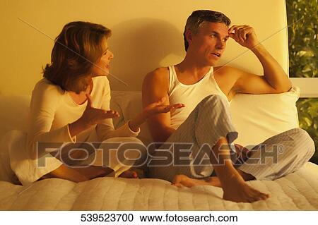 Stock Image - Woman arguing with a man in the bedroom. Fotosearch