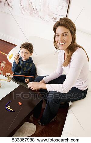 Woman assisting her son in assembling a toy View Large Photo Image Stock Photo - Woman assisting her son in assembling a toy. Fotosearch