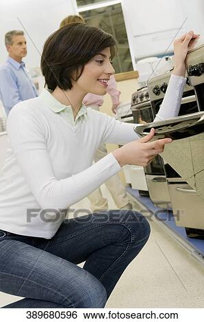 Woman buying stove in a supermarket View Large Photo Image Stock Photograph - Woman buying stove in a supermarket. Fotosearch