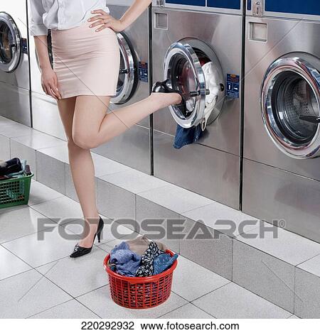 Woman closing the lid of a washing machine with her leg View Large Photo Image Stock Image - Woman closing the lid of a washing machine with her leg. Fotosearch