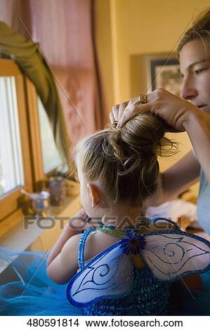 Woman dressing up her daughter View Large Photo Image Picture - Woman dressing up her daughter. Fotosearch