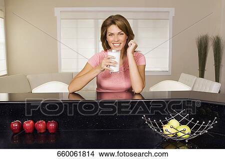 Woman drinking milk from a glass View Large Photo Image Picture - Woman drinking milk from a glass. Fotosearch