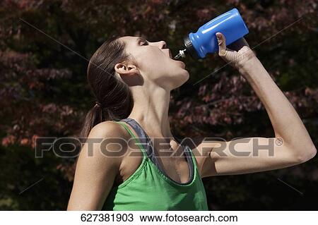 Woman drinking water after exercise View Large Photo Image Stock Image - Woman drinking water after exercise. Fotosearch