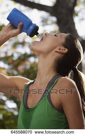 Woman drinking water after exercise View Large Photo Image Stock Image - Woman drinking water after exercise. Fotosearch