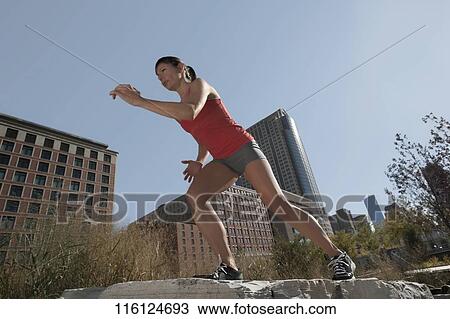 Stock Image - Woman exercising on a stone. Fotosearch