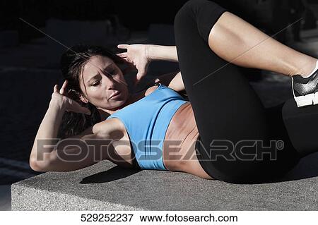 Woman exercising on a stone View Large Photo Image Stock Photo - Woman exercising on a stone. Fotosearch