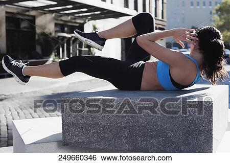 Woman exercising on a stone View Large Photo Image Stock Photograph - Woman exercising on a stone. Fotosearch