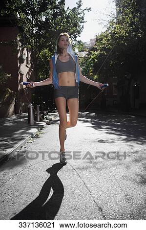 Woman exercising with a jump rope in a street View Large Photo Image Stock Image - Woman exercising with a jump rope in a street. Fotosearch