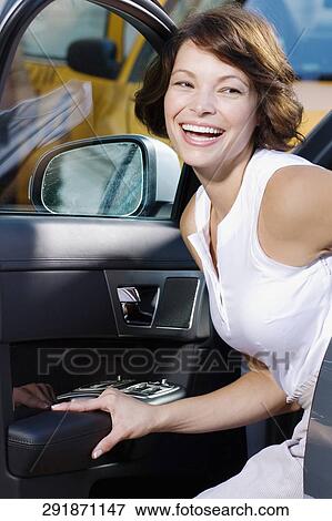 Stock Photo - Woman getting out of a car and smiling, Biltmore Hotel, Coral Gables, Florida, USA. Fotosearch