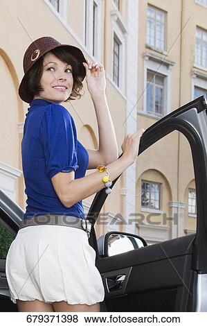 Stock Photo - Woman getting out of a car and smiling, Biltmore Hotel, Coral Gables, Florida, USA. Fotosearch