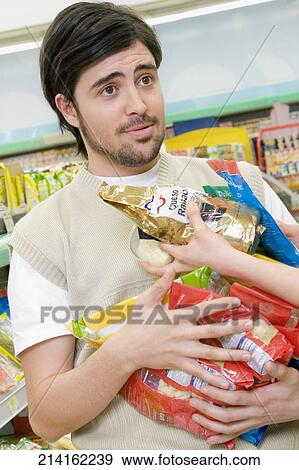 Stock Photo - Woman giving groceries to a man in a supermarket. Fotosearch