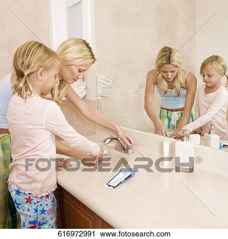 Woman helping her daughter in brushing teeth View Large Photo Image Stock Image - Woman helping her daughter in brushing teeth. Fotosearch