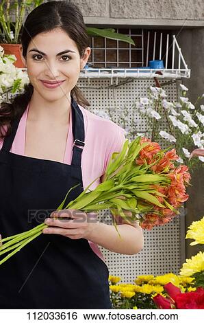 Woman holding a bouquet of flowers and smiling View Large Photo Image Stock Photograph - Woman holding a bouquet of flowers and smiling. Fotosearch