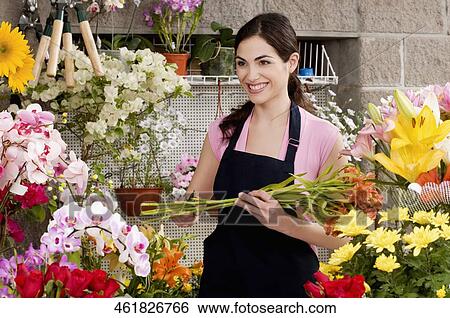 Woman holding a bouquet of flowers and smiling View Large Photo Image Stock Photograph - Woman holding a bouquet of flowers and smiling. Fotosearch