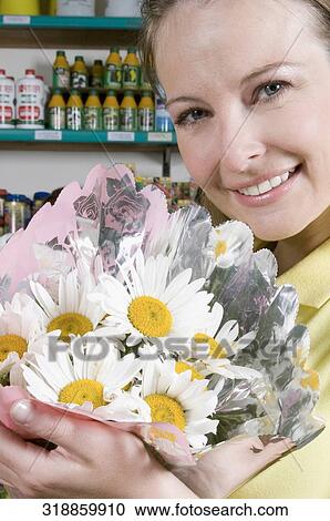 Stock Image - Woman holding a bouquet of flowers. Fotosearch