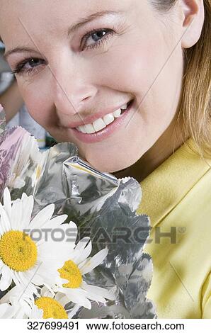 Woman holding a bouquet of flowers View Large Photo Image Stock Image - Woman holding a bouquet of flowers. Fotosearch