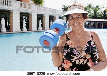 Stock Photograph - Woman holding a dumbbell at poolside, Biltmore Hotel, Coral Gables, Florida, USA. Fotosearch