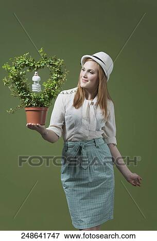 Woman holding a flower pot with a light bulb View Large Photo Image Stock Photo - Woman holding a flower pot with a light bulb. Fotosearch