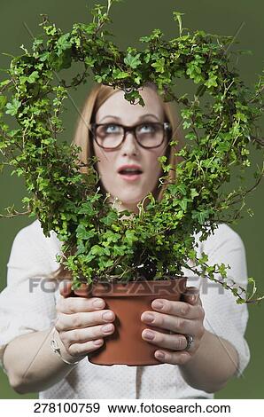 Woman holding a potted wreath View Large Photo Image Stock Photo - Woman holding a potted wreath. Fotosearch