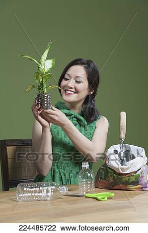 Stock Image - Woman holding a seedling. Fotosearch