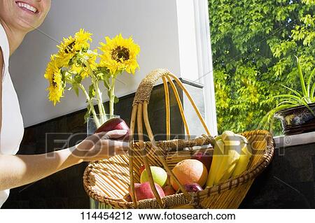 Stock Image - Woman holding an apple and smiling. Fotosearch