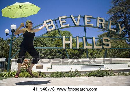 Woman holding an umbrella and jumping, Beverly Hills, Los Angeles County, California, USA View Large Photo Image Stock Photo - Woman holding an umbrella and jumping, Beverly Hills, Los Angeles County, California, USA. Fotosearch