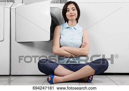 Woman in a laundromat View Large Photo Image Stock Image - Woman in a laundromat. Fotosearch