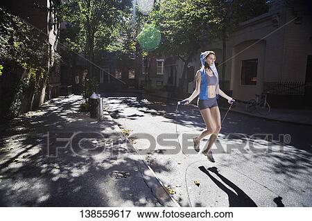 Woman jumping with a rope in the street View Large Photo Image Stock Photo - Woman jumping with a rope in the street. Fotosearch