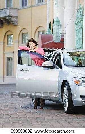 Woman leaning against a car door and smiling, Biltmore Hotel, Coral Gables, Florida, USA View Large Photo Image Stock Image - Woman leaning against a car door and smiling, Biltmore Hotel, Coral Gables, Florida, USA. Fotosearch