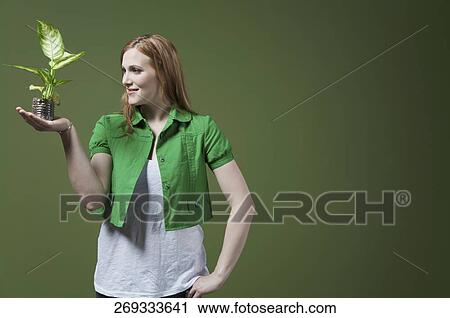 Stock Image - Woman looking at a seedling. Fotosearch